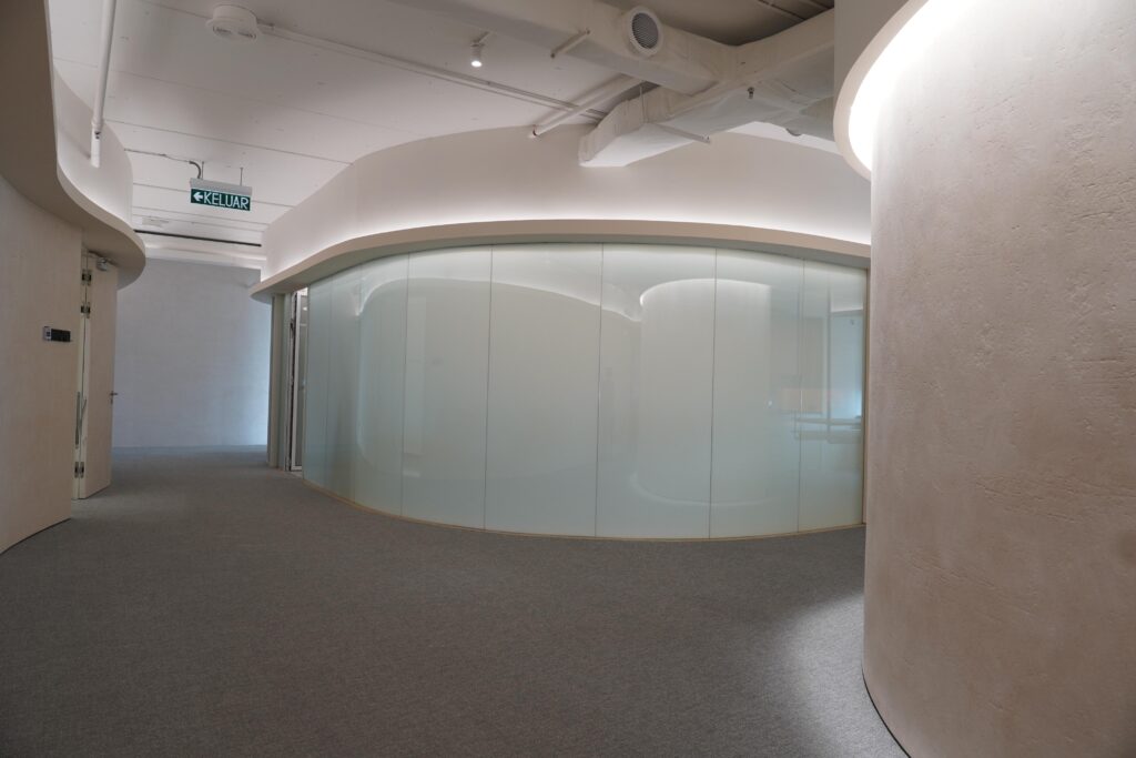 曲線を描いだ会議室で使用する、瞬間調光型の曲げガラス。デザインと機能を兼ね備えた万能な内装ガラス